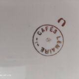 Oval plate with a light green rim and golden frieze, Cafés Lemaire.