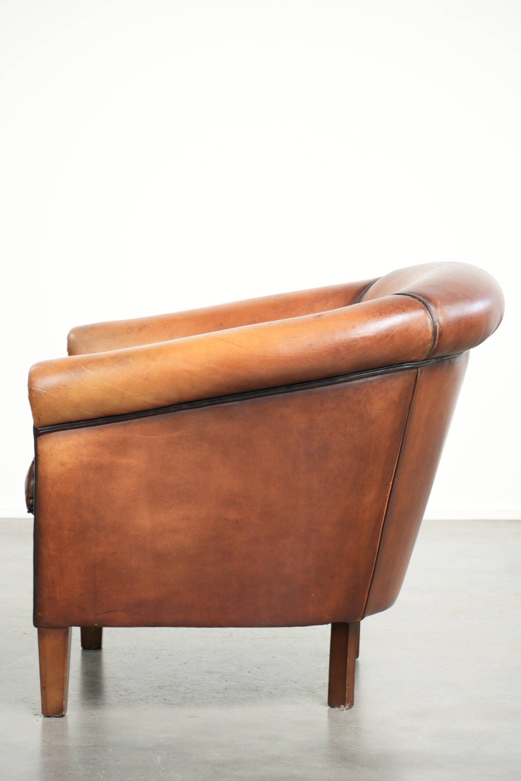 Vintage sheepskin club armchair finished with black piping