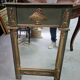 Empire-style mirror in deep green lacquered wood richly enhanced.