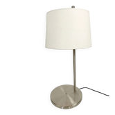 Large brushed metal table lamp with an ecru shade.