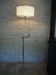 Flexible floor lamp, chrome, opaque white shade with metallic edges.