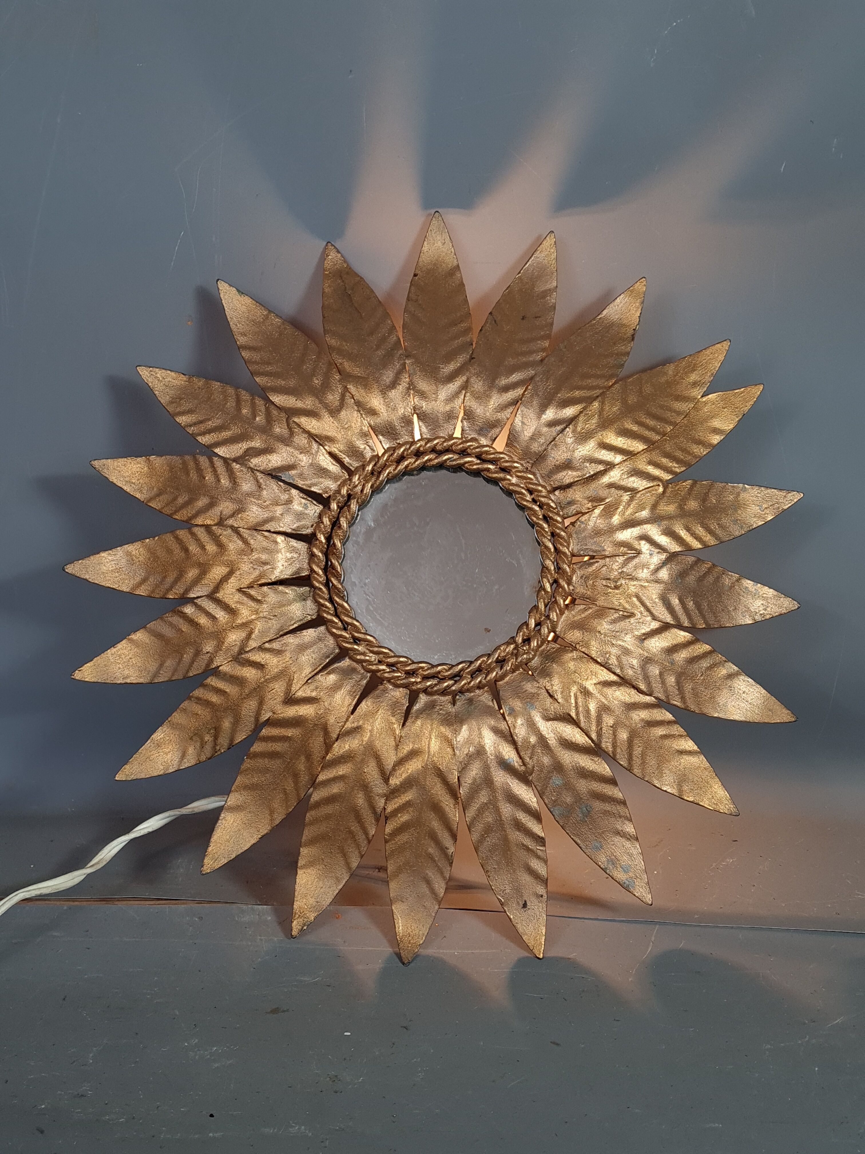 Wall lamp forming sun in gilded brass and with a mirror. Vintage 50s.