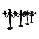 Set of four black glass candle holders.