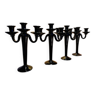 Set of four black glass candle holders.