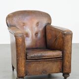 Fauteuil ancien en cuir de mouton sur roulettes et patiné