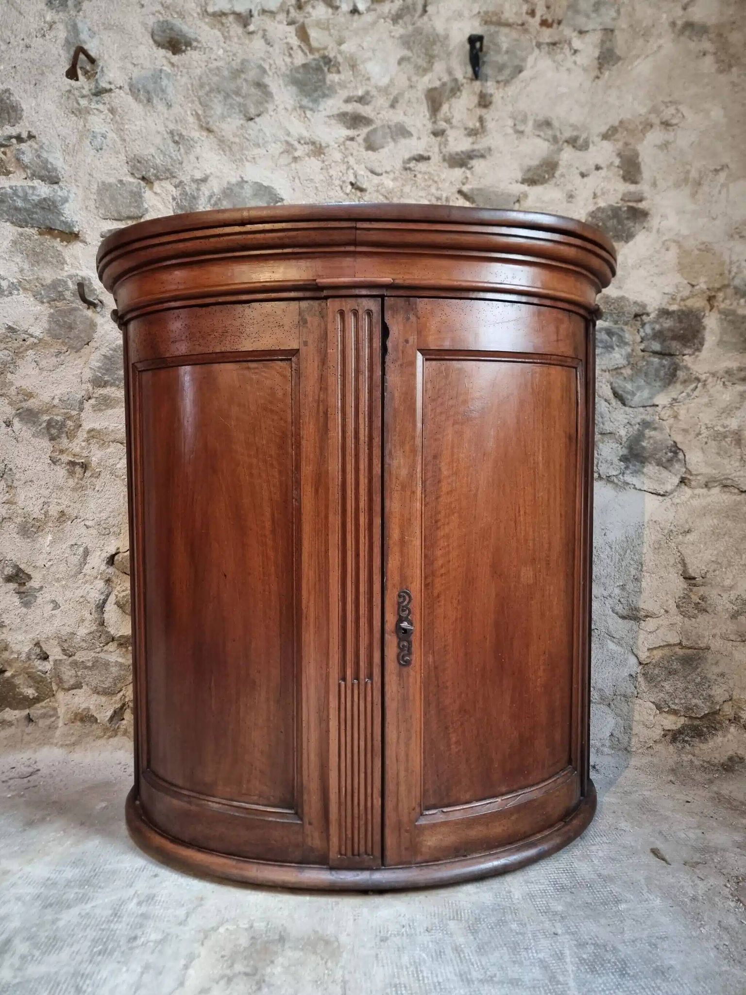 Antique demi-lune cabinet in walnut, late 18th century, French château.