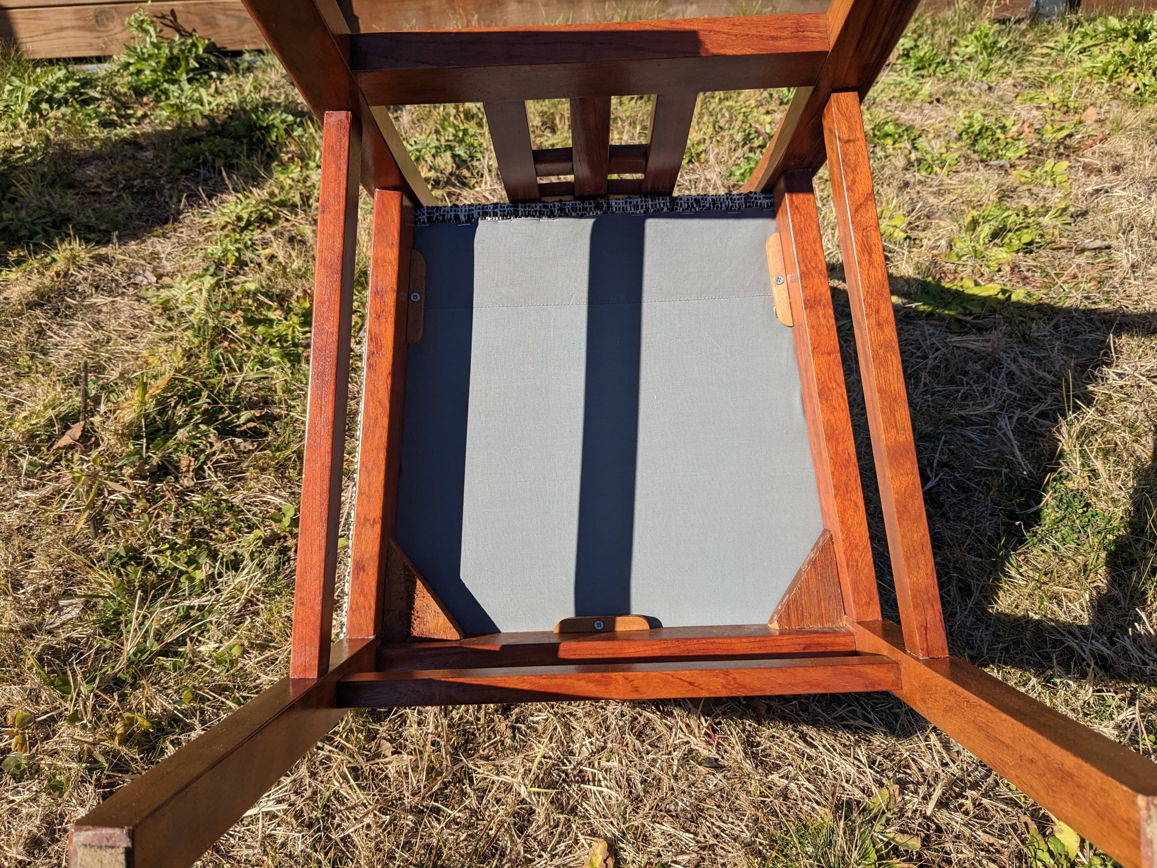 Set of 8 teak lounge chairs with high backs and zebra-striped seats