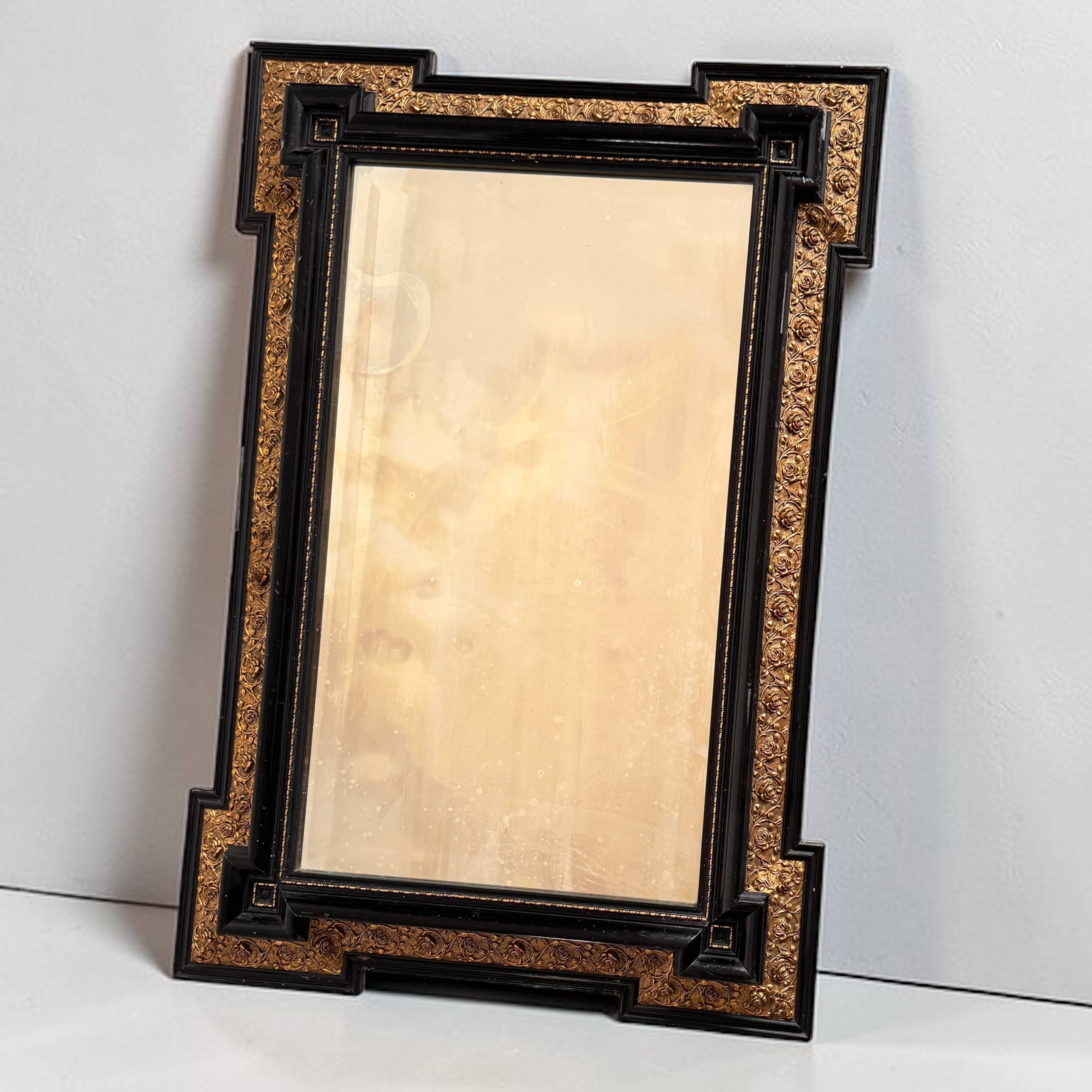 Antique wall mirror in blackened wood and gilded stucco, 19th-century Dutch style.