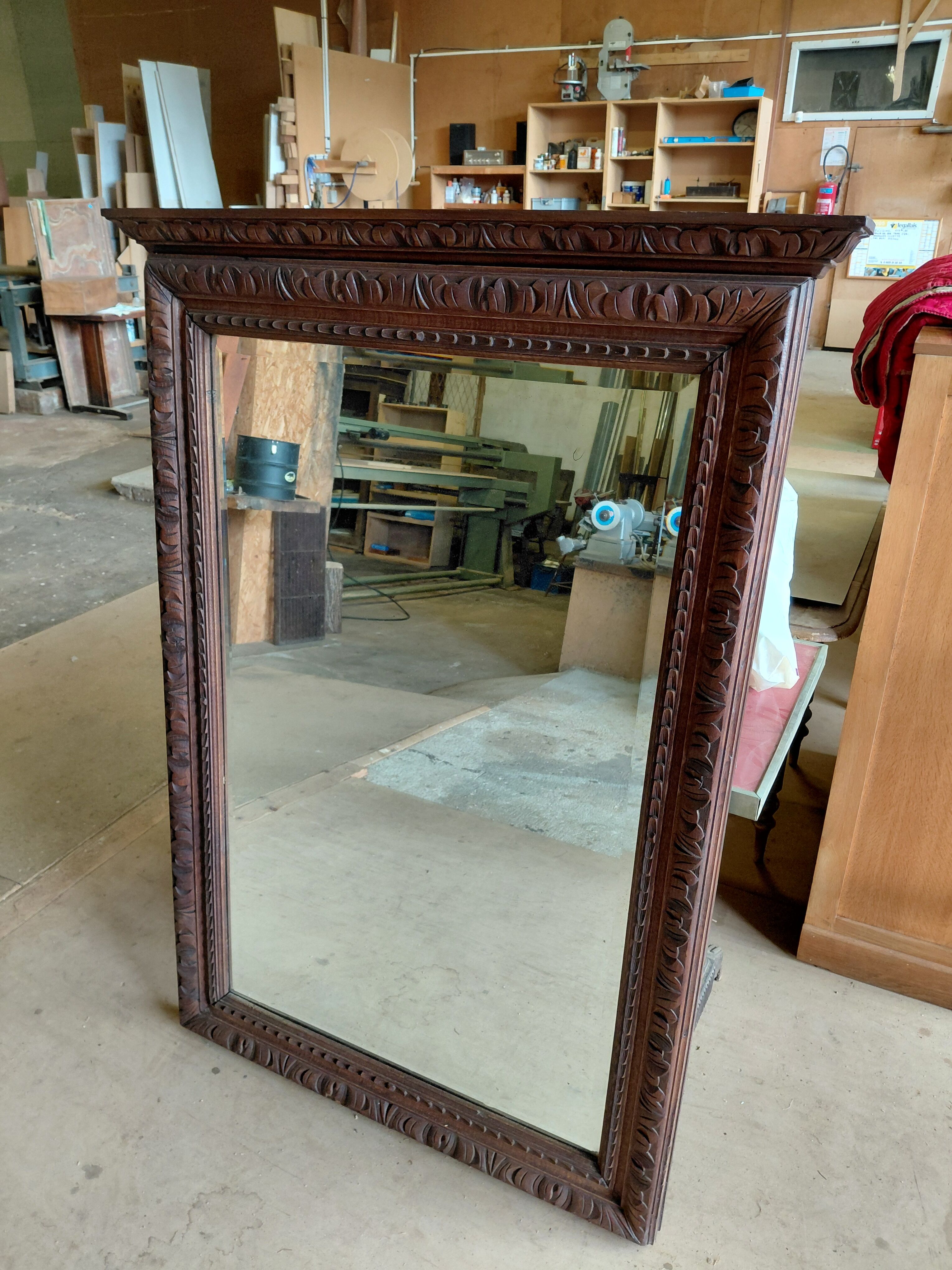Large bevelled mirror with a carved wooden frame