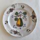 Two earthenware plates with fruits, pears and plums.