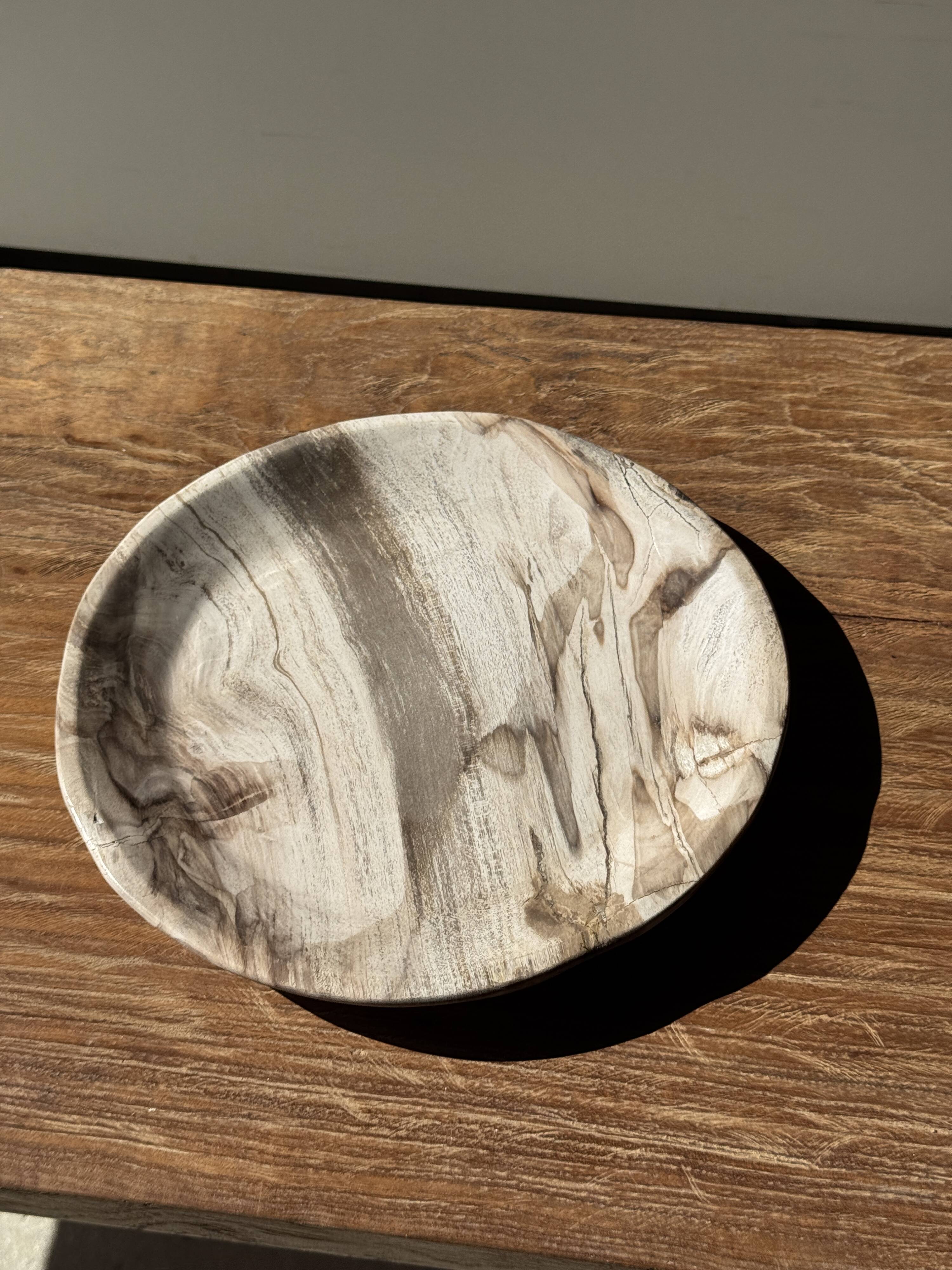 Tray, circular dish or plate made of white striped grey petrified wood.