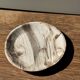 Tray, circular dish or plate made of white striped grey petrified wood.