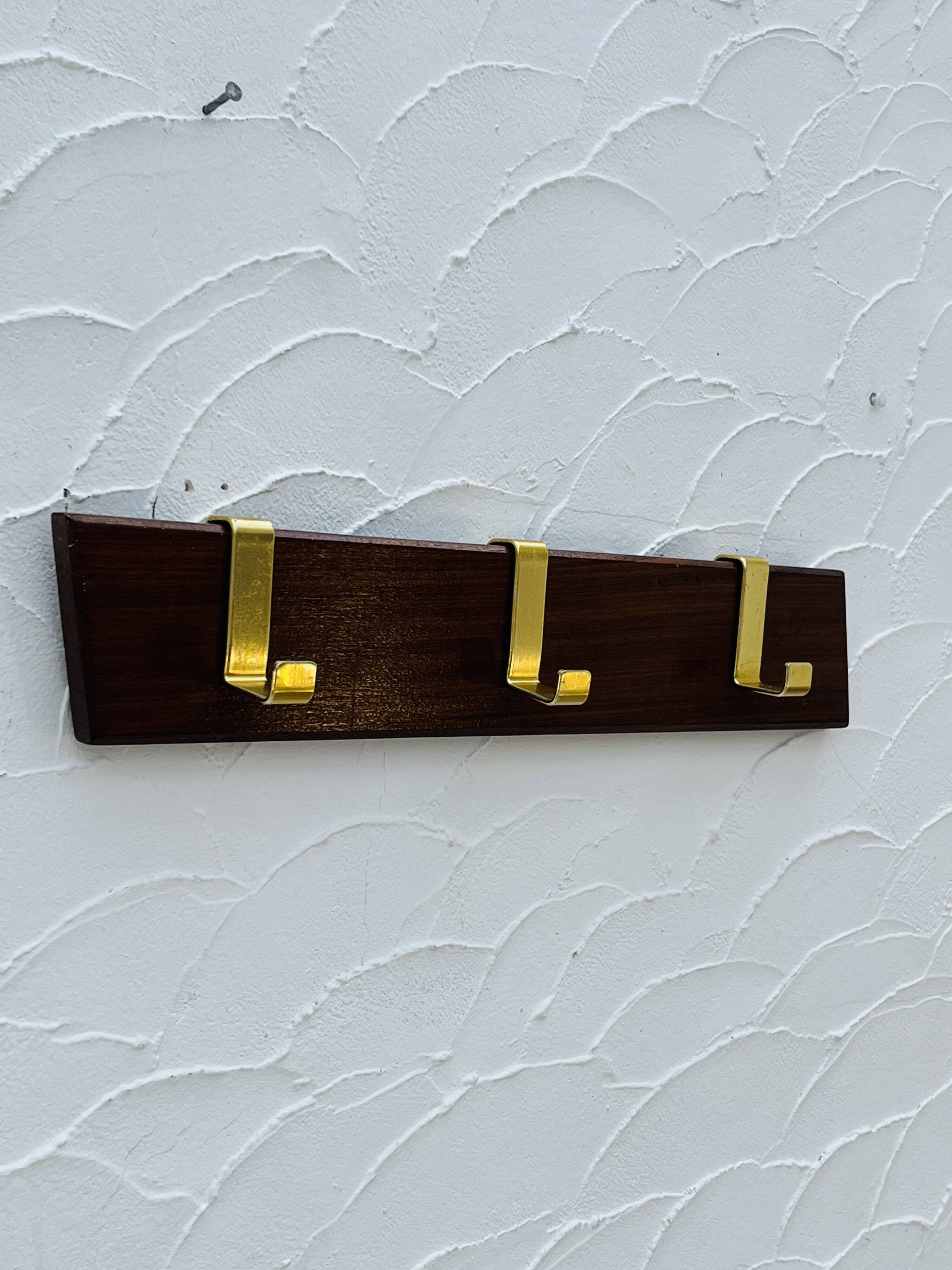 Vintage wooden and brass coat rack with 3 hooks from the 1960s.