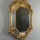 Antique octagonal mirror in richly carved gilded wood, Louis XV style.
