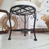 Black iron stool/pouf with its boucle fabric cushion.