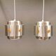 Two Space-Age hanging lamps, in silver-coloured aluminium with orange prisms.