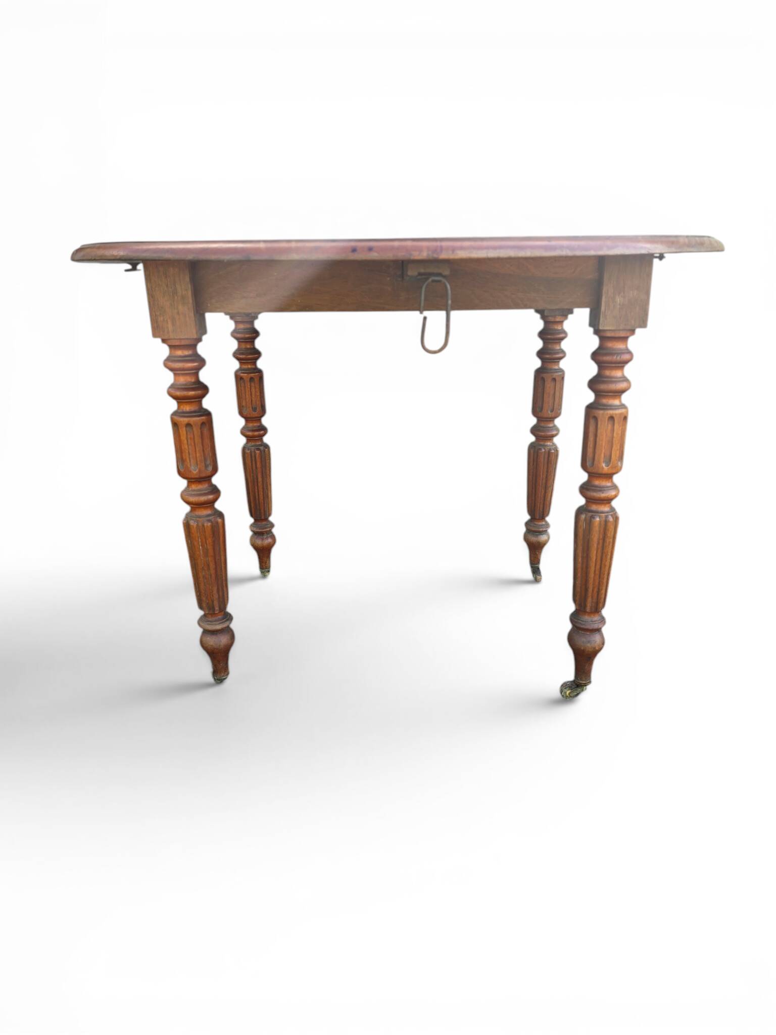 Antique drop-leaf table in wood, with turned legs and castors.