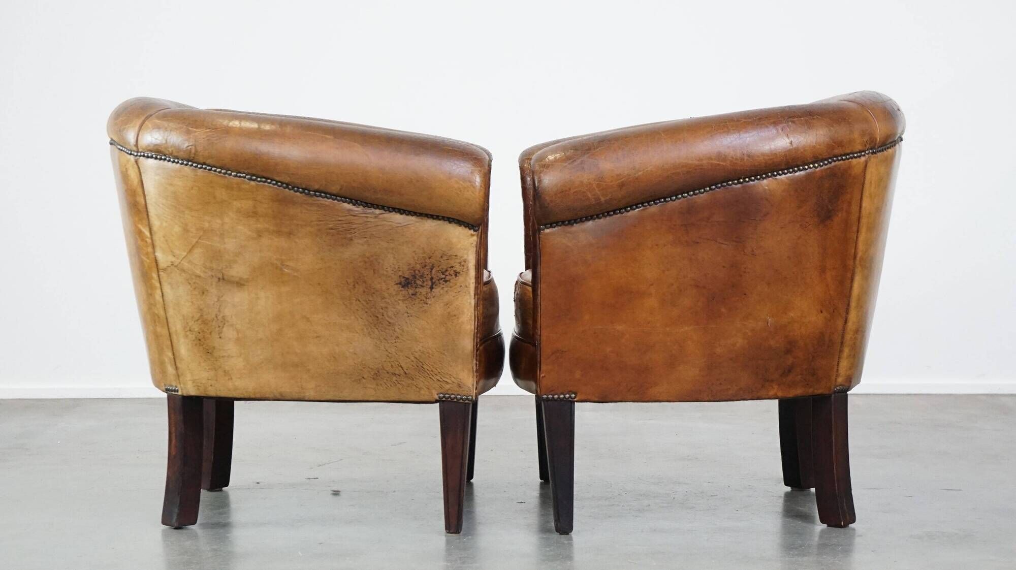 Set of 2 subtle, stately and sturdy club chairs made of sheepskin