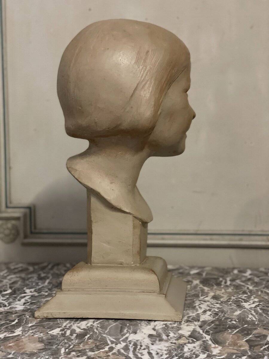 Plaster bust, young girl, monogram and date.