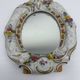 Antique porcelain mirror from Dresden with relief flowers and rococo decoration.