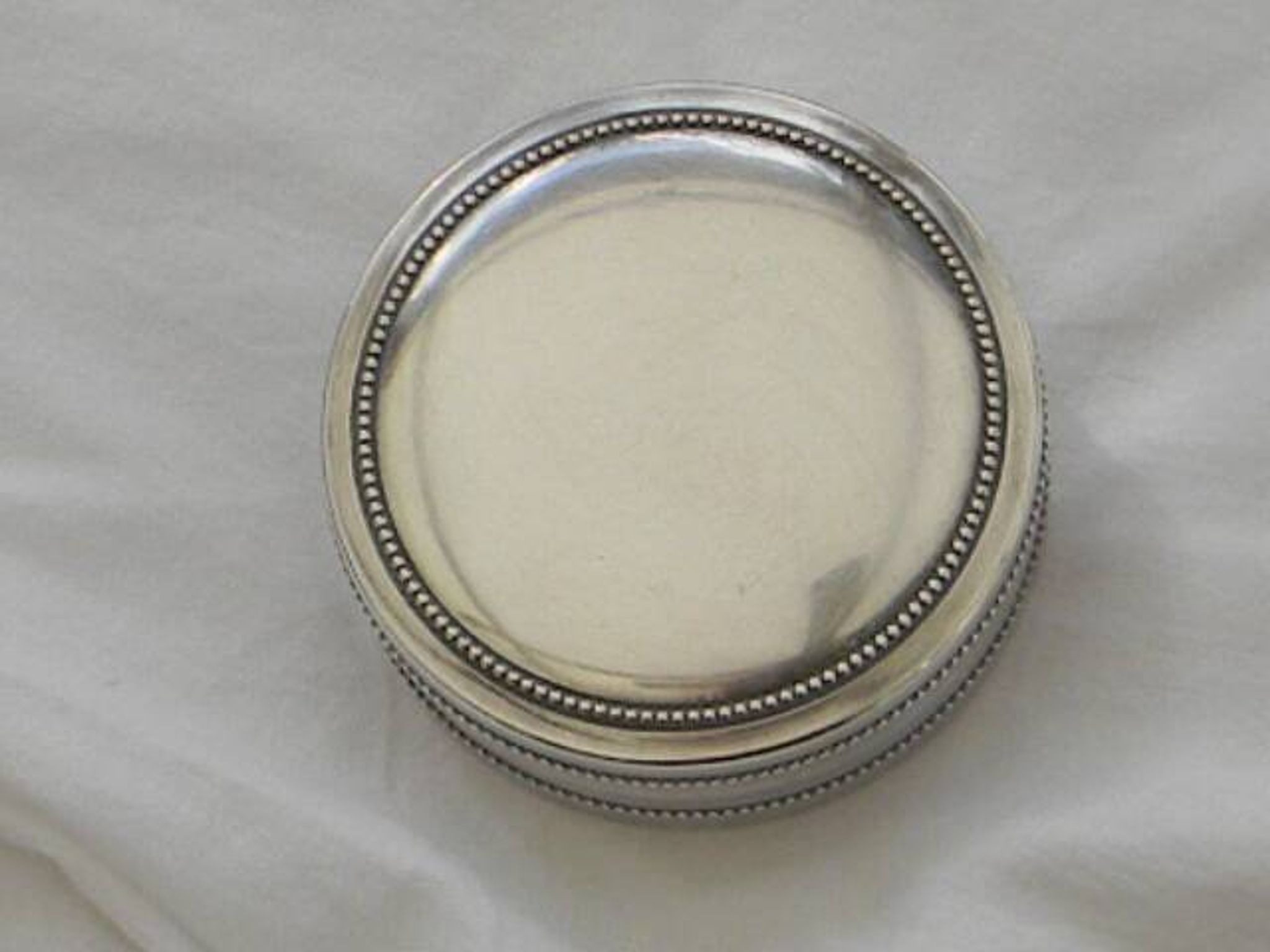 Small round silver metal box SNPA.
