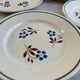 Set of 4 small flat plates with floral designs.