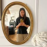 Oval mirror in antique gilded wood