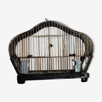 Metal bird cage with porcelain feeders.