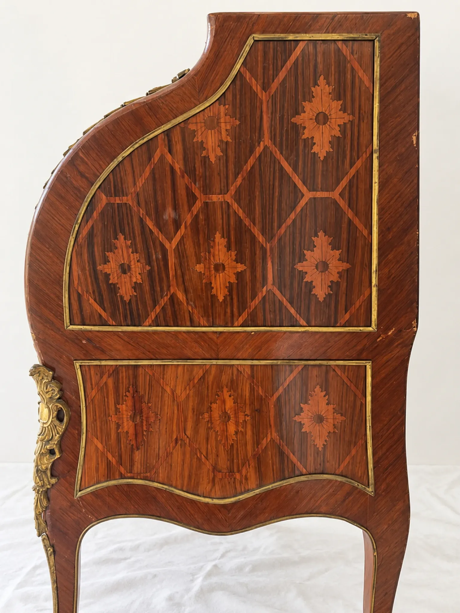 Louis XV cylinder desk with floral marquetry and gilded ornaments.