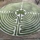Circular rug with green decor on a cream background from the Labyrinth.