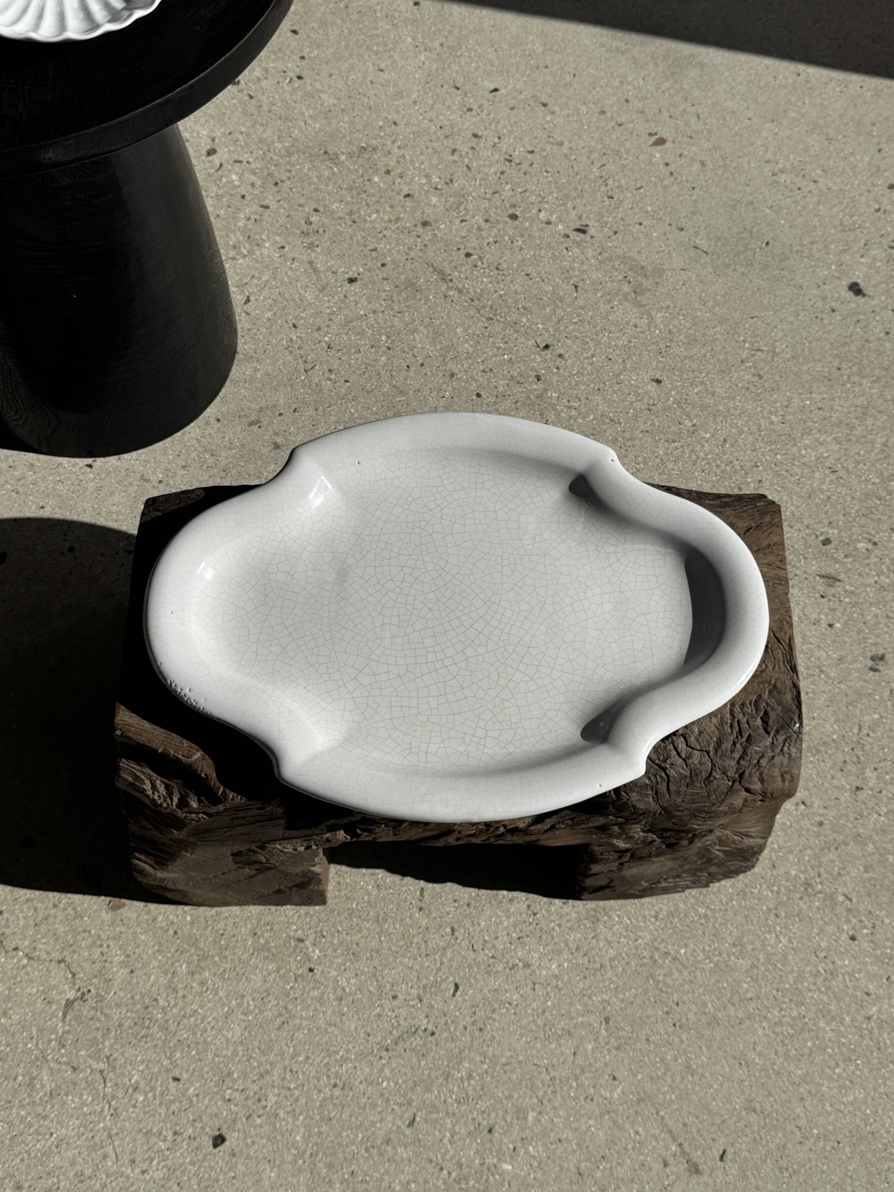 Antique oval-shaped white crackled faience plate with a scalloped edge.