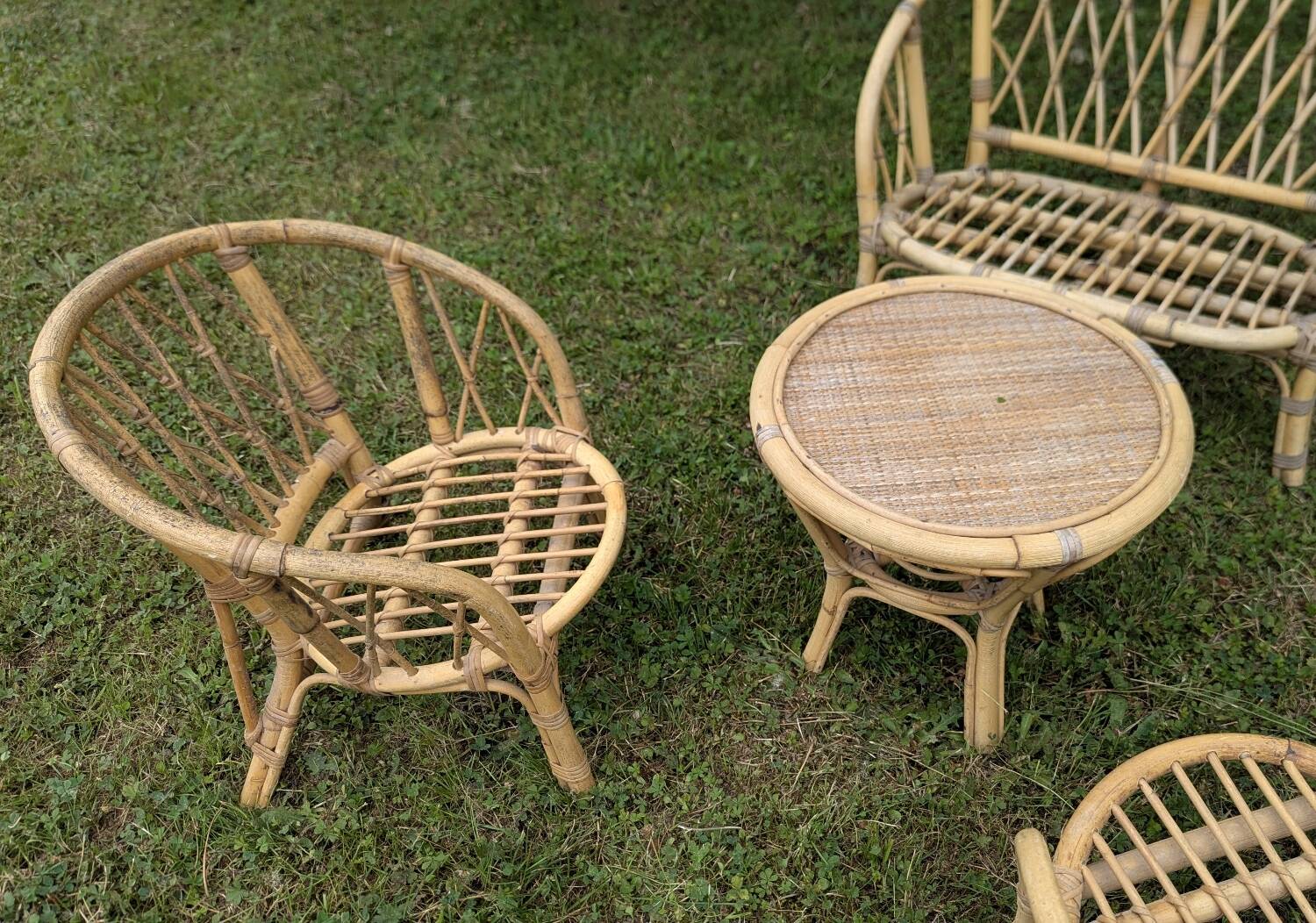 Set of children's rattan garden furniture from the 1950s and 1960s, including chairs, table, and bench.