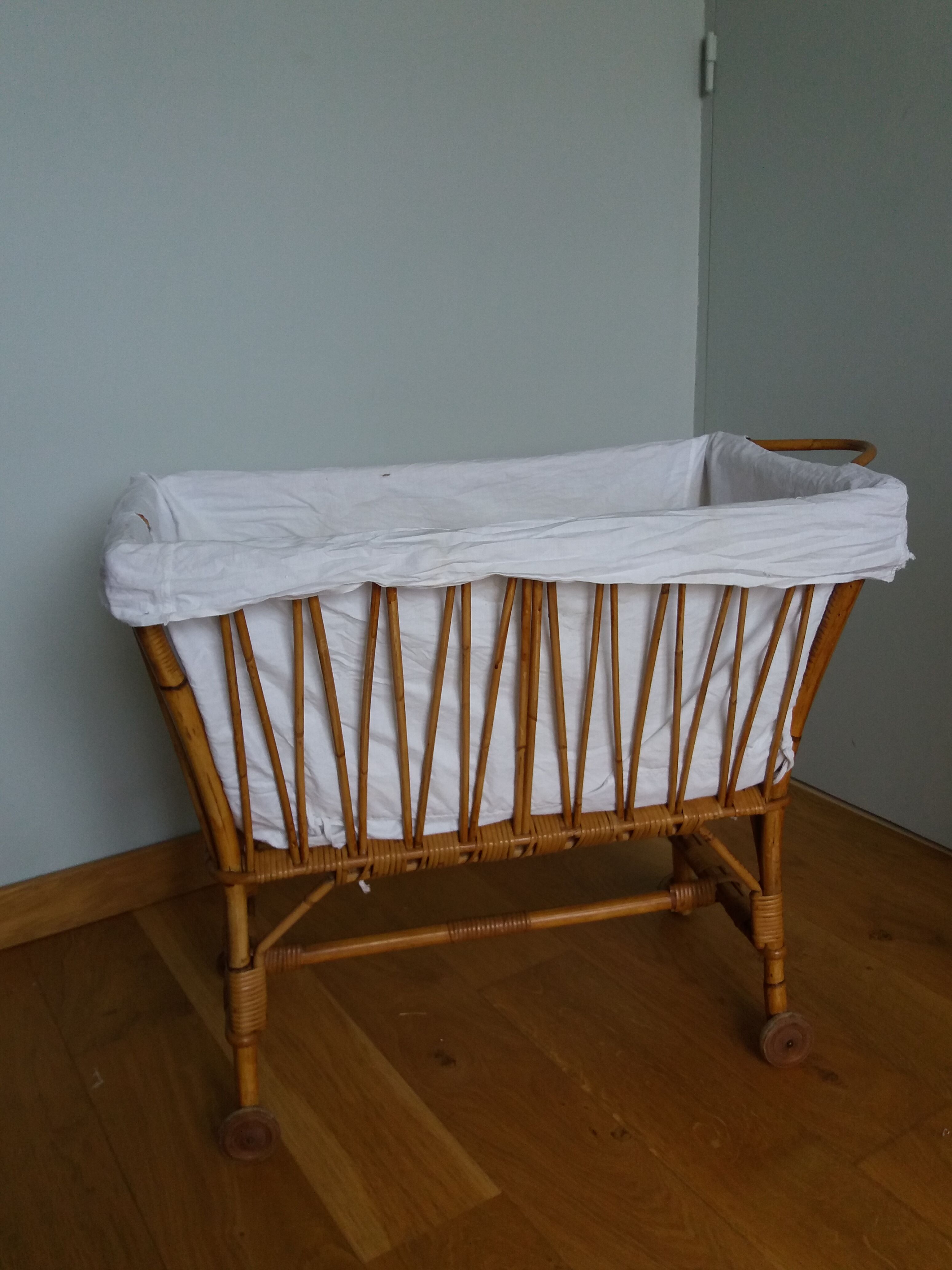 Rattan wicker cradle on wooden wheels
