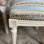 Pair of Louis XVI style chairs in painted wood and satin, classic elegance.