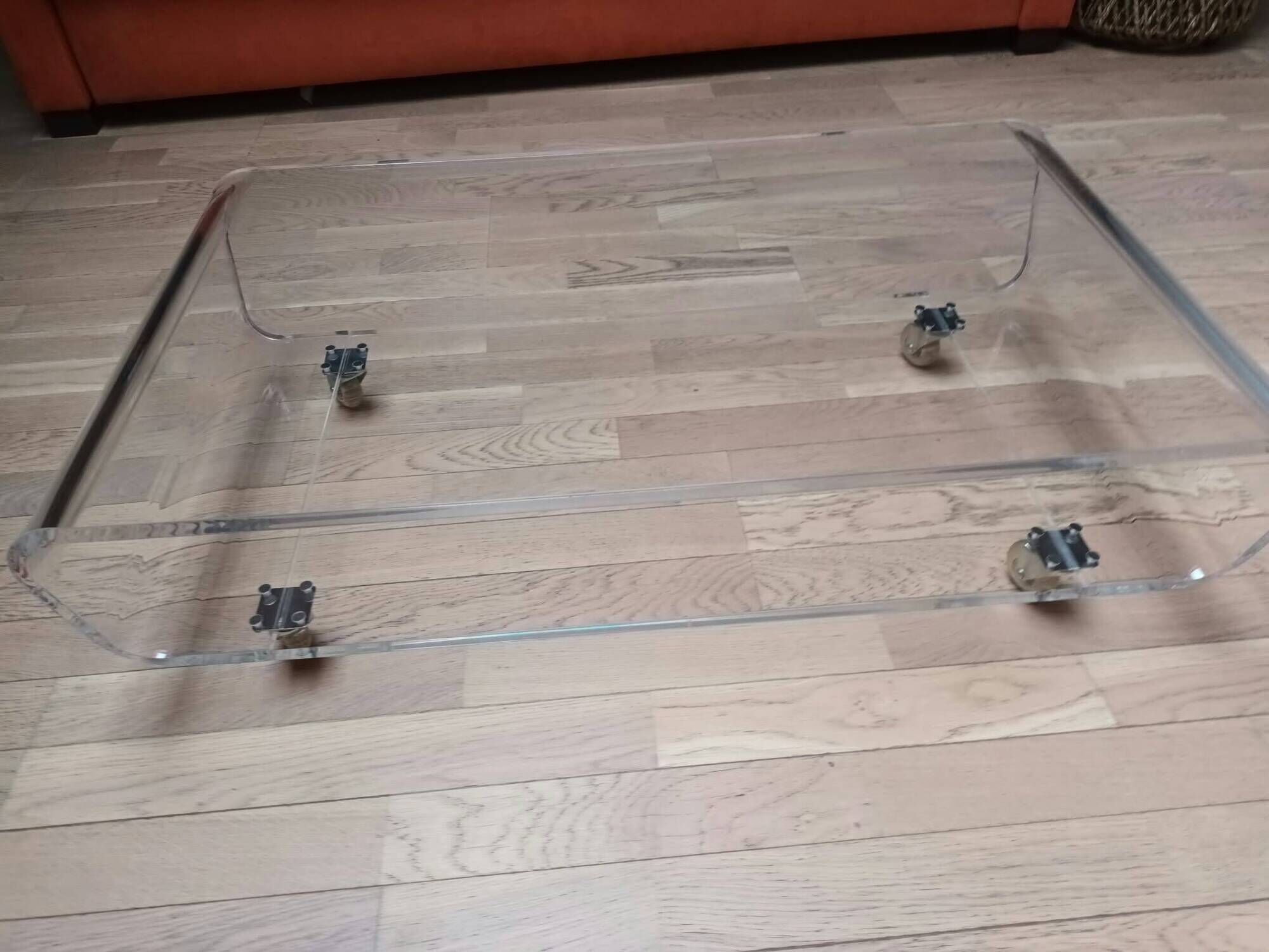 Design coffee table from Habitat in transparent plexiglass, mounted on wheels.
