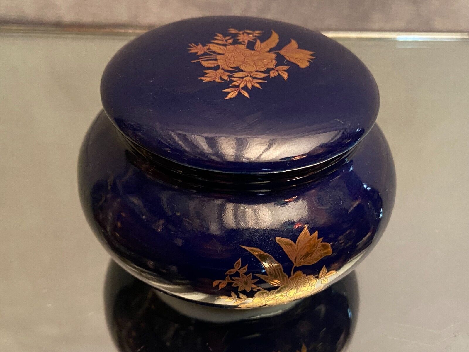 Porcelain candy box with golden floral decoration on a midnight blue background