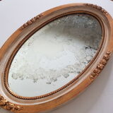 Large oval mirror with bevelled ice in stucque and wood decorated with flowers