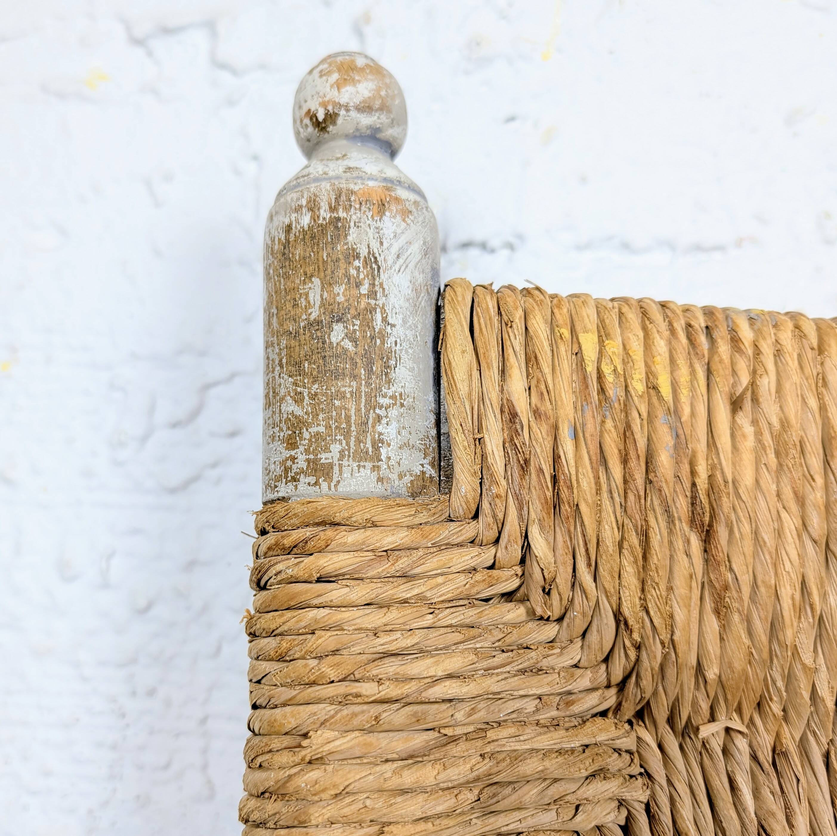 Rustic chair made of turned wood and straw.