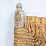 Rustic chair made of turned wood and straw.