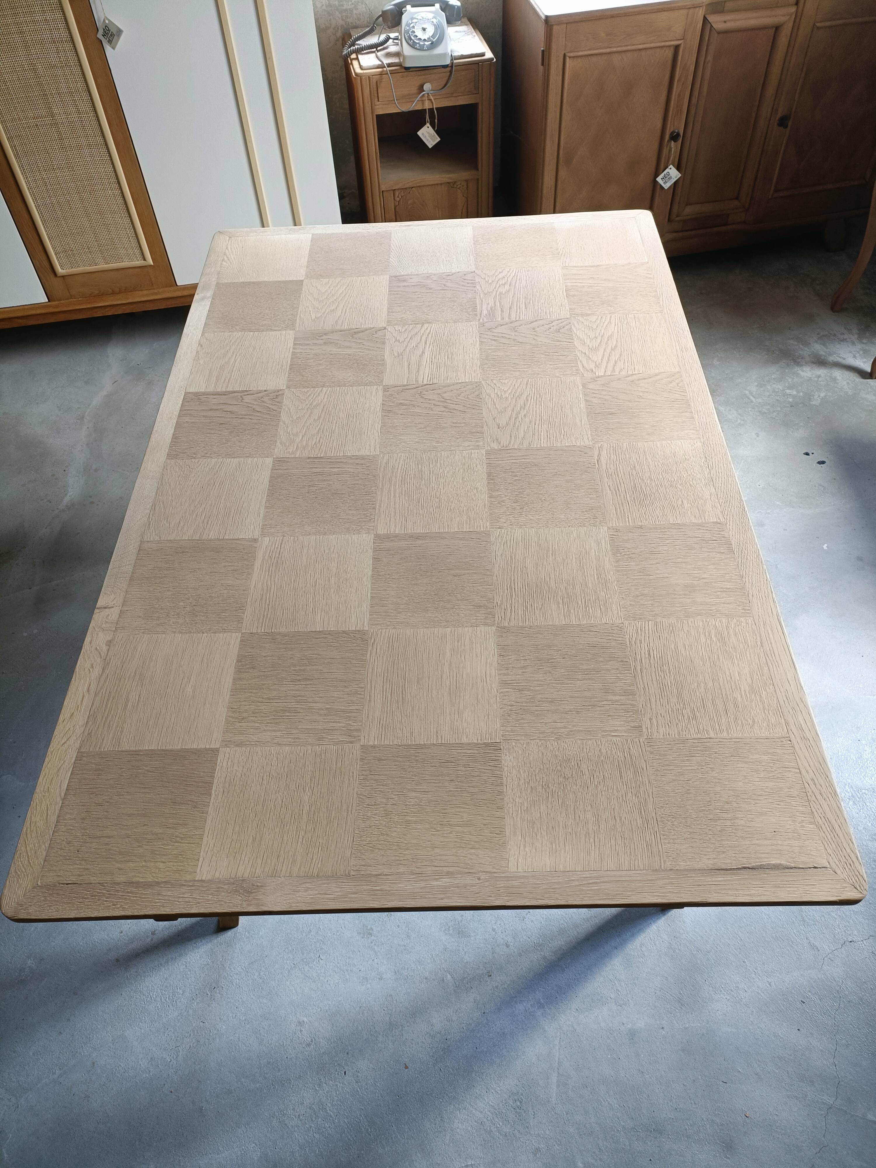 Oak dining table with a checkerboard top and extensions.