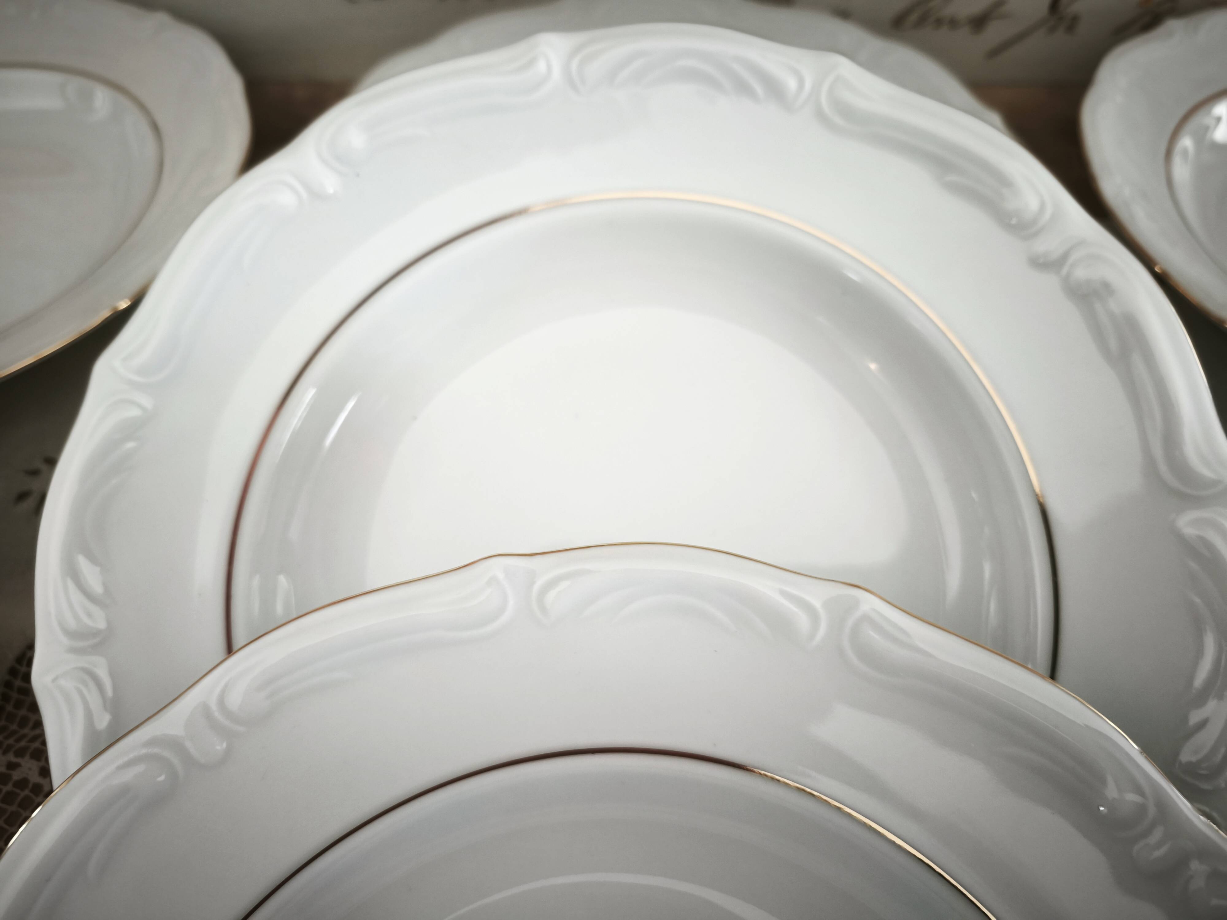 12 deep plates in porcelain with double gold trim.