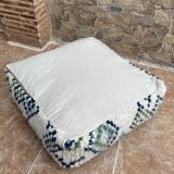 Berber floor pouf: Handwoven Moroccan wool cushion.