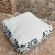 Berber floor pouf: Handwoven Moroccan wool cushion.