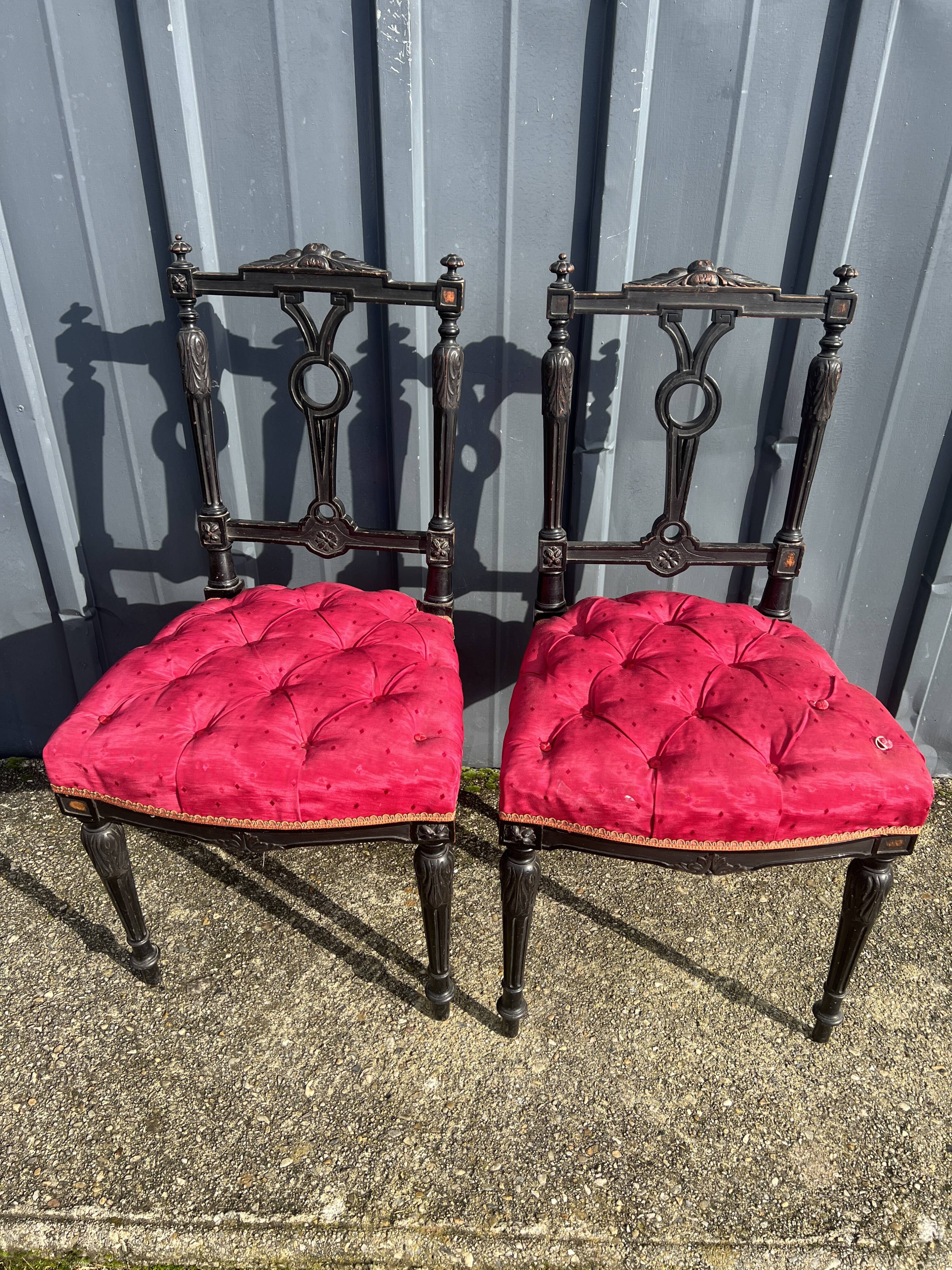 Pair of black lacquered chairs with purple tufted upholstery.