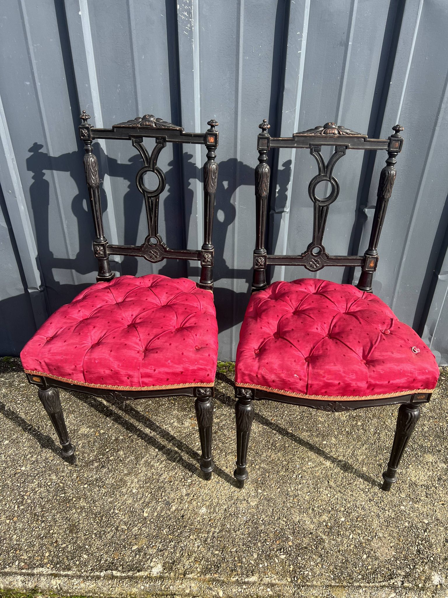 Pair of black lacquered chairs with purple tufted upholstery.