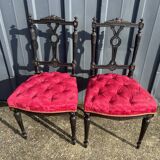 Pair of black lacquered chairs with purple tufted upholstery.