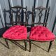 Pair of black lacquered chairs with purple tufted upholstery.