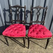 Pair of black lacquered chairs with purple tufted upholstery.