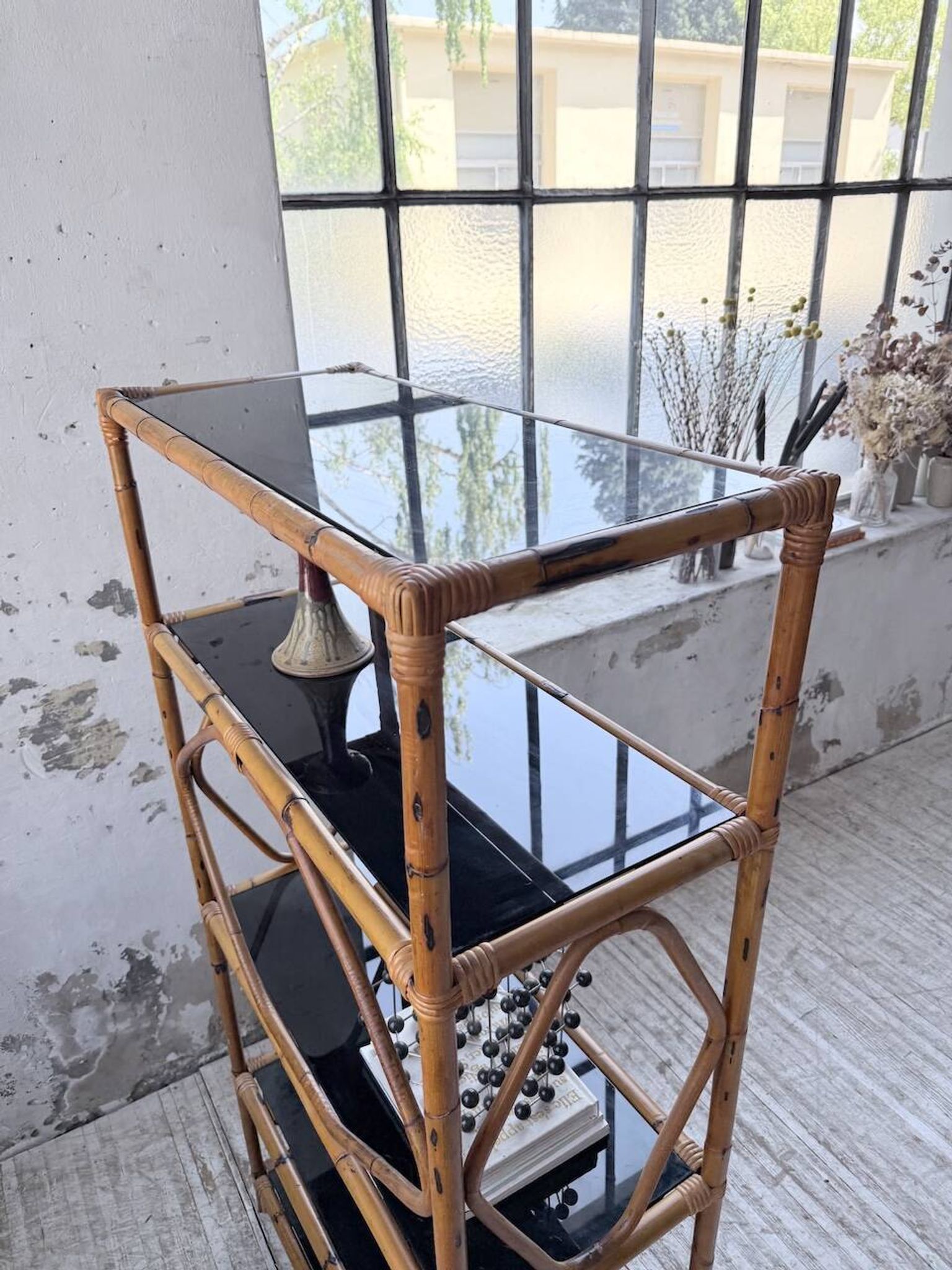 Rattan bookshelf and black glasses