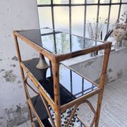 Rattan bookshelf and black glasses